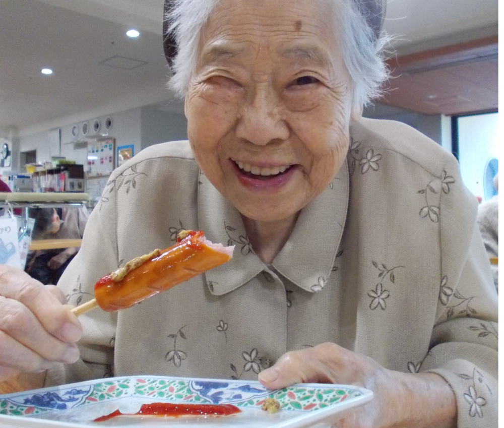 フランクフルトを食べる入居者さま